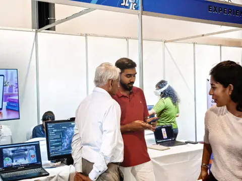 A team member demonstrating the application on a phone while talking with visitors