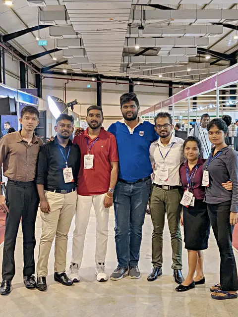 The exhibition team posing together with visitors inside the exhibition hall