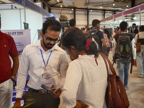 A visitor trying the application on a phone with a member of the team